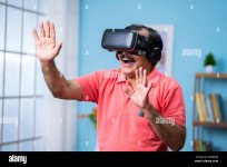 happy-indian-senior-man-with-vr-or-virtual-reality-headset-experiencing-metaverse-at-home-conc...jpg